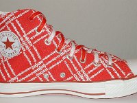 Product Red High Top Chucks  Inside patch view of a left Product Red high top with red and white reversible shoelaces.