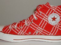 Product Red High Top Chucks  Inside patch view of a right Product Red high top with red and white reversible shoelaces.