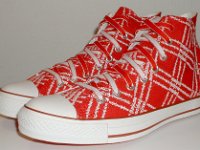 Product Red High Top Chucks  Angled side view of Product Red high tops with red and white reversible shoelaces.
