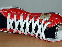 Red and Black 2-Tone Chucks  Left red and black 2-tone high top, new with tag, sideways top view.