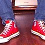 Red High Top Chucks  Kicking back in red high tops, front view.