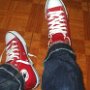 Red High Top Chucks  Wearing unlaced red high top chucks, top view.