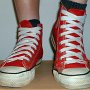 Red High Top Chucks  Stepping in red high tops with wide laces, front view.