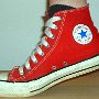 Red High Top Chucks  Taking a step in a right red high top, inside patch view.