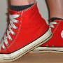 Red High Top Chucks  Stepping in red high tops with wide laces, left outside view.