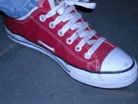 Red Low Cut Chucks  Wearing a left red low cut chuck, angled side view.