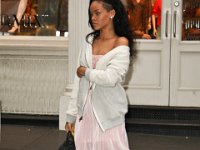 Rihanna  Rihanna walking in front of a store wearing black high top chucks.