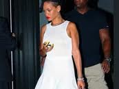 Rihanna  Rihanna walking out a doorway wearing black high top chucks.