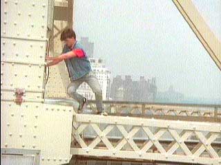 George starts to climb to the edge of the bridge's metalwork.