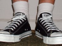 Socks for Your Chucks  All white quarter high socks worn with black low cuts, front view.