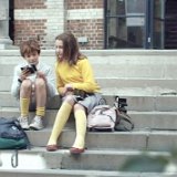 SpaceBoy  Jim and Emma seated on the front steps of their school looking at photos.