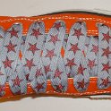 Star Print Shoelaces on Chucks  Orange high top chuck with red and silver star print shoelaces.