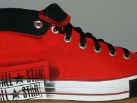 Stencil Chucks  Outside view of a rolled down right red stencil high top with black toe cap, toe guard, and laces.