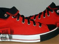 Stencil Chucks  Outside view of rolled down red stencil high tops with black toe caps, toe guards, and laces.