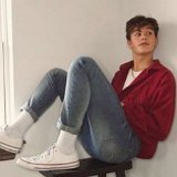 Teen Boys Wearing Chucks  Teen perched on a stool wearing a white tee shirt, red sweater, blue jeans, and optical white low top chucks with white crew socks.