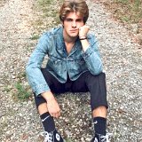 Teen Boys Wearing Chucks  Teen pondering life seated on a gravel path outdoors dressed in a blue denim work shirt, black jeans, and black high top chucks worn with black Nike socks.