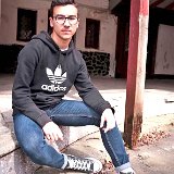 Teen Boys Wearing Chucks  Teen seated outside on front stairs wearing a grey adidas hoodie, blue jeans, and black high top chucks with white crew socks.