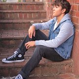 Teen Boys Wearing Chucks  Teen seated on red brick stairs wearing a white tee shirt,  blue denim and cloth hoodie, black jeans, and black high top chucks.