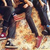 The Strokes  Closeup of the band members wearing black, maroon, and American flag print high top chucks.