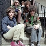 The Strokes  The band seated on cement steps showing off  their well worn maroon and black high top chucks.