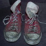 Trashed High Top Chucks  Dirty well worn red high tops, front view.