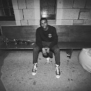 Vince Staples  Vince Staples sits alone backstage at a show wearing black high top chucks.