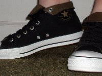 Wearing Rolled Down High Top Chucks  Left side view of black and olive foldovers with fat black laces.