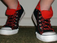 Wearing Rolled Down High Top Chucks  Laening forward in black and red foldovers with red and black laces.