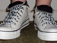 Wearing Rolled Down High Top Chucks  Front view of white and black foldovers laced with black and white checkered shoelaces.