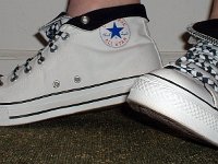 Wearing Rolled Down High Top Chucks  Left side view of white and black foldovers laced with black and white checkered shoelaces.
