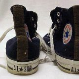 Worn Black High Top Chucks  Worn black felt high tops with brown felt tongue and rear trim and embroidered side patch, rear view.