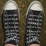 Worn Black High Top Chucks  Top view of worn black high tops with checkered straight lacing.