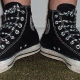 Worn Black High Top Chucks  Angled front view of worn black high tops with checkered straight lacing.