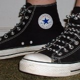Worn Black High Top Chucks  Left side view of worn black high tops with checkered straight lacing.