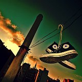 Worn Black High Top Chucks  Black high tops hanging from a telephone wire.