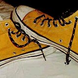 Yellow Chucks  Inside patch view of gold high top chucks black shoelaces.
